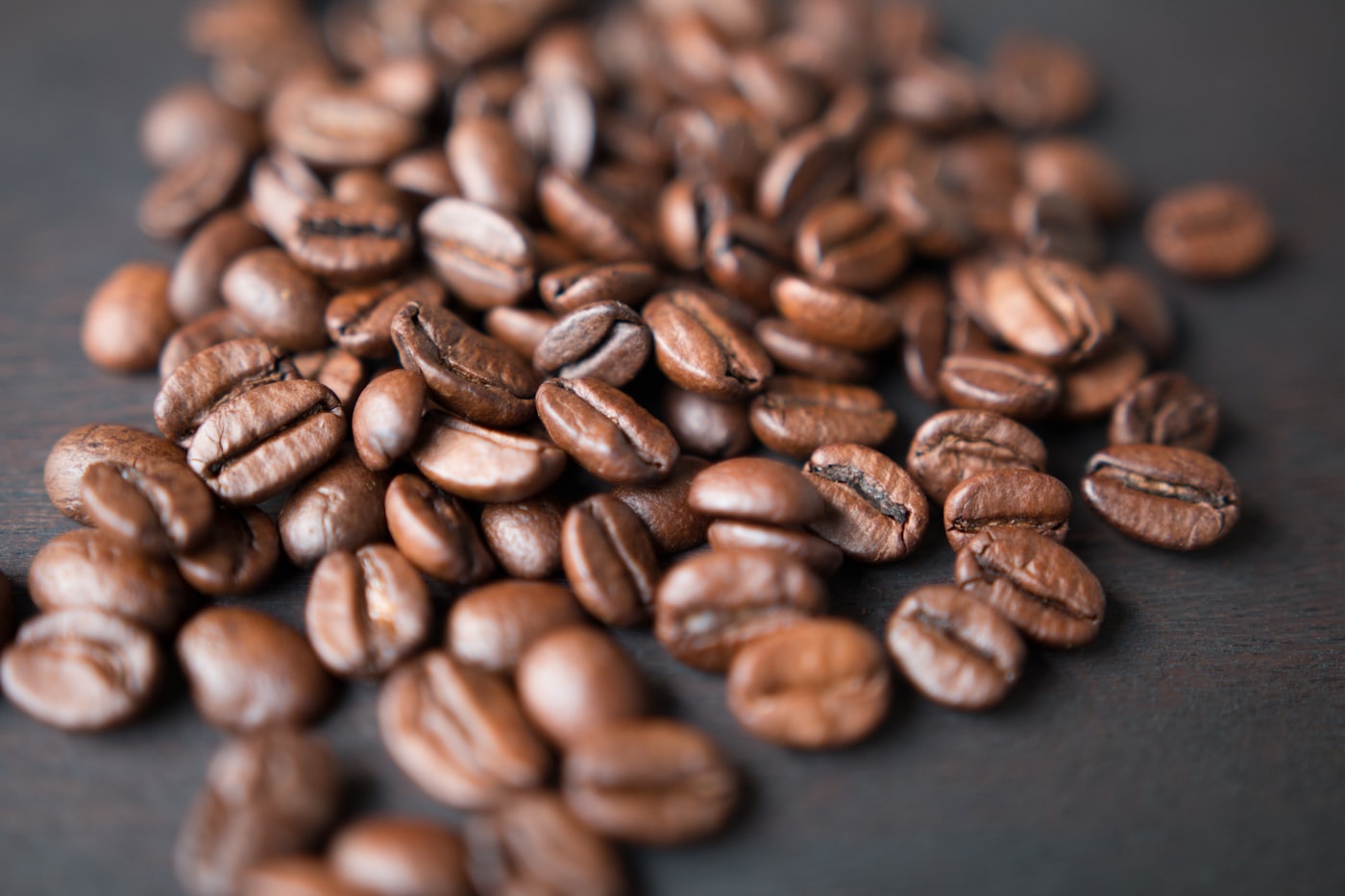 A shop-floor coffee roaster mid-batch, beans tumbling in the drum