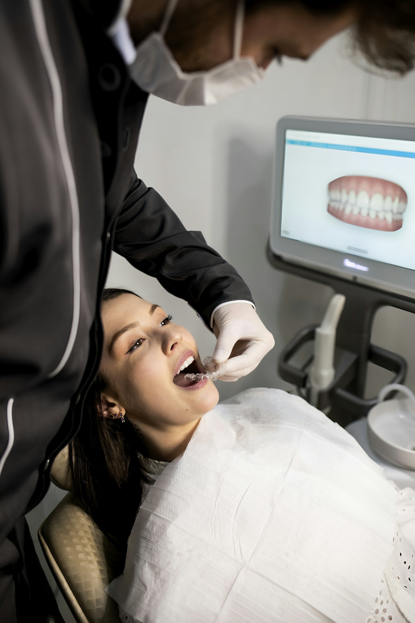 A dentist showing a patient information on a screen
